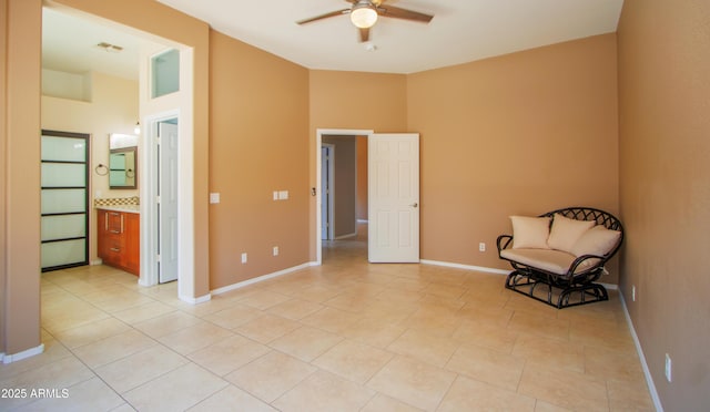 unfurnished room with ceiling fan, baseboards, and light tile patterned floors