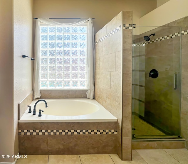 full bath featuring a stall shower, tile patterned floors, a garden tub, and plenty of natural light