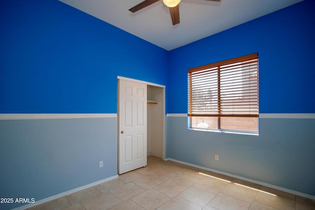 unfurnished bedroom featuring baseboards, a closet, a ceiling fan, and tile patterned flooring