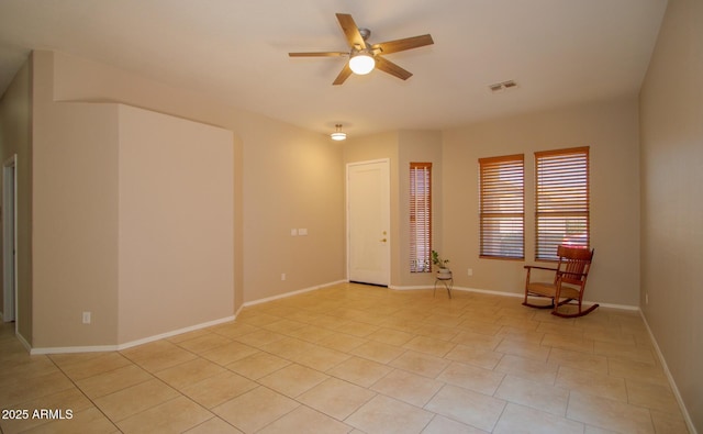 unfurnished room featuring a ceiling fan, light tile patterned floors, and baseboards