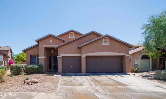 mediterranean / spanish house featuring a garage, stucco siding, driveway, and a tiled roof