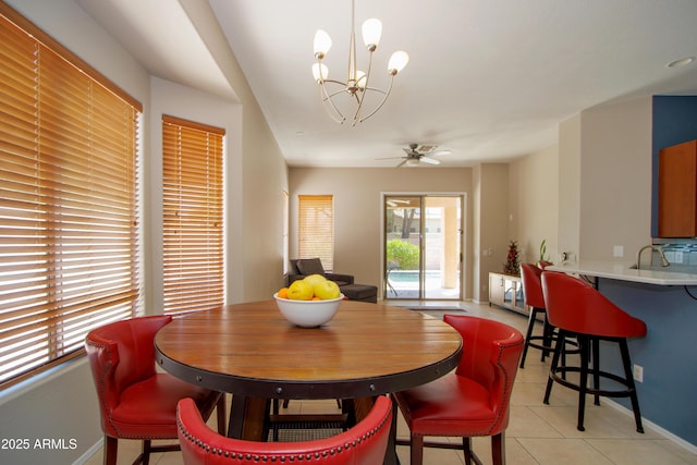 dining area with a chandelier, light tile patterned floors, a ceiling fan, and baseboards