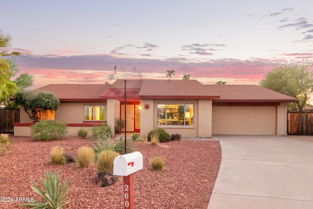 pueblo-style home with a garage, driveway, and stucco siding