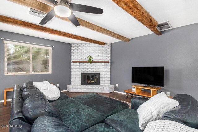 living area with a fireplace, visible vents, baseboards, dark wood-style floors, and beamed ceiling