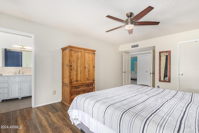 bedroom featuring dark wood-type flooring, visible vents, a sink, and a textured ceiling