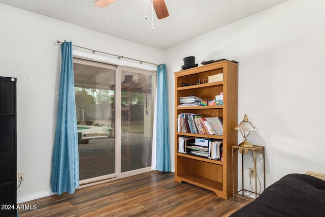 interior space featuring a textured ceiling, access to outside, dark wood-style flooring, and ceiling fan