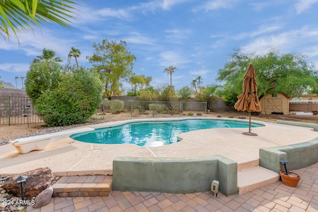 view of pool with a diving board, a patio area, a fenced backyard, and a fenced in pool