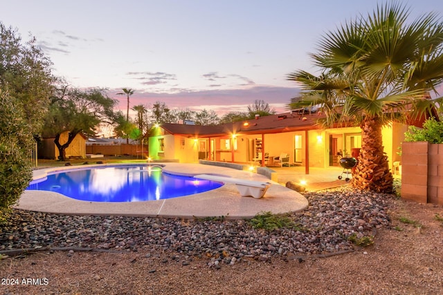 view of pool with a fenced in pool, a patio area, and a diving board