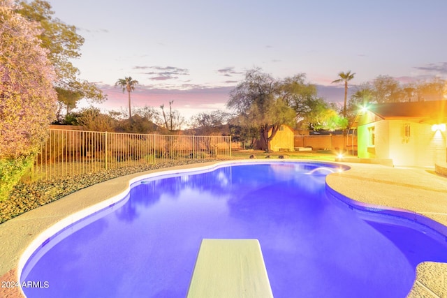 pool at dusk featuring a fenced backyard and a fenced in pool