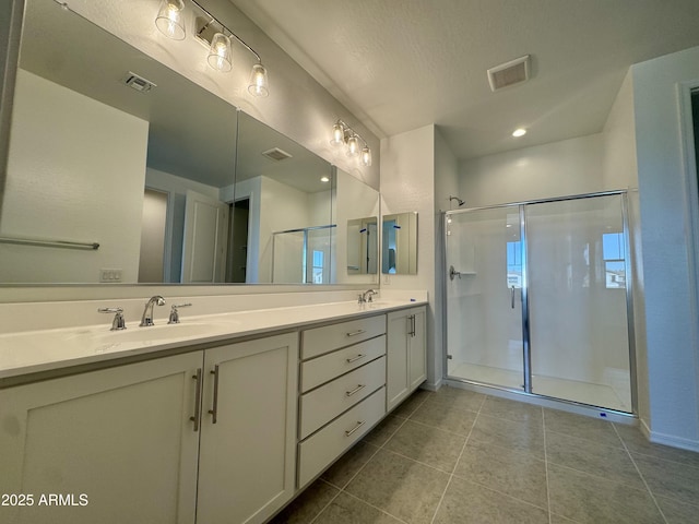 bathroom featuring a sink, visible vents, double vanity, and a shower stall