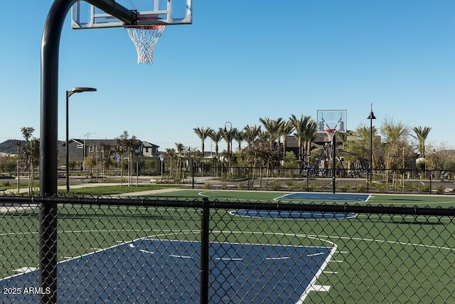 view of basketball court with community basketball court and fence