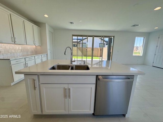 kitchen featuring visible vents, a sink, white cabinets, stainless steel dishwasher, and tasteful backsplash