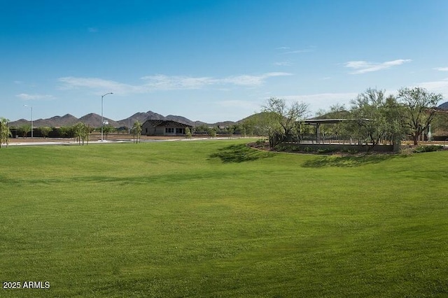 view of property's community featuring a lawn and a mountain view