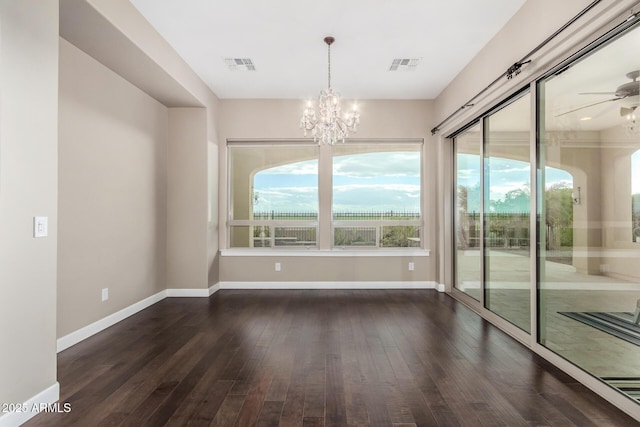 unfurnished dining area with ceiling fan with notable chandelier and dark hardwood / wood-style flooring