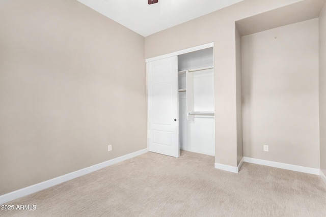 unfurnished bedroom featuring light colored carpet, ceiling fan, and a closet