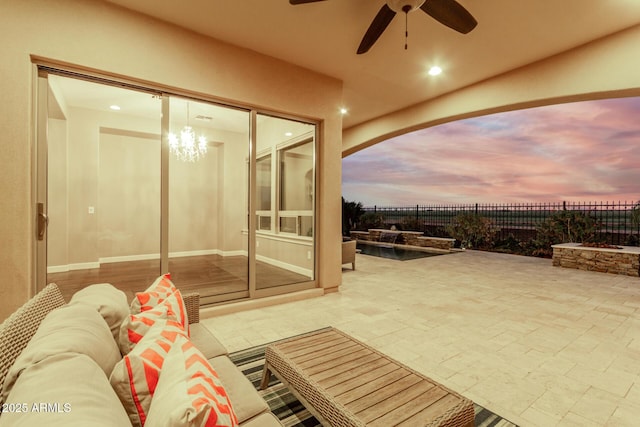 patio terrace at dusk featuring an outdoor living space and ceiling fan