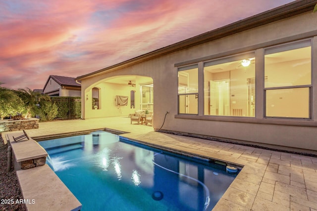 pool at dusk with a patio area