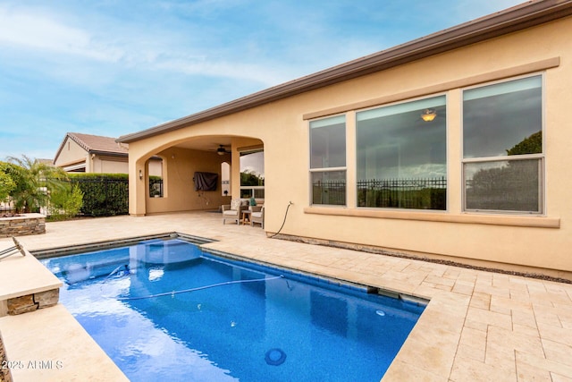 view of swimming pool featuring ceiling fan, a jacuzzi, and a patio area