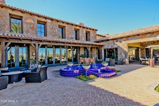 rear view of house featuring outdoor lounge area, a patio area, and french doors