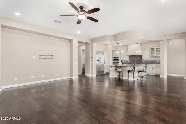 unfurnished living room featuring ceiling fan and dark hardwood / wood-style flooring