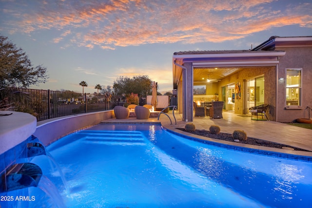 pool at dusk featuring a patio area