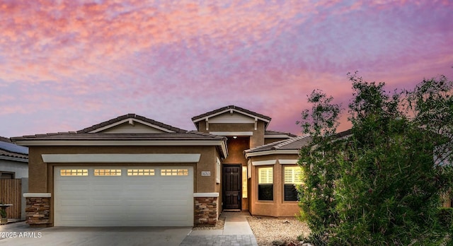 16763 W Magnolia St, Goodyear, AZ 85338 - view of front facade featuring concrete driveway, stone siding, stucco siding, and a garage