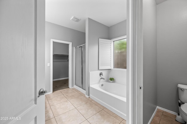 16763 W Magnolia St, Goodyear, AZ 85338 - full bath with a garden tub, tile patterned flooring, toilet, a shower stall, and a spacious closet