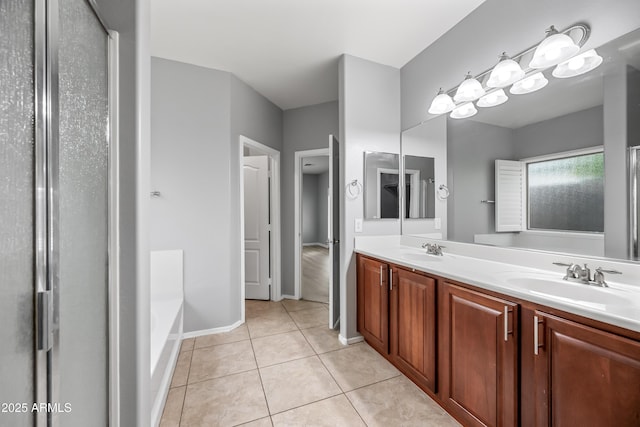 16763 W Magnolia St, Goodyear, AZ 85338 - full bathroom with double vanity, tile patterned floors, a bath, a shower, and baseboards