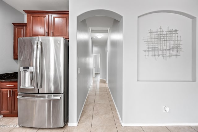 16763 W Magnolia St, Goodyear, AZ 85338 - kitchen with stainless steel refrigerator with ice dispenser, light tile patterned floors, dark stone countertops, and baseboards