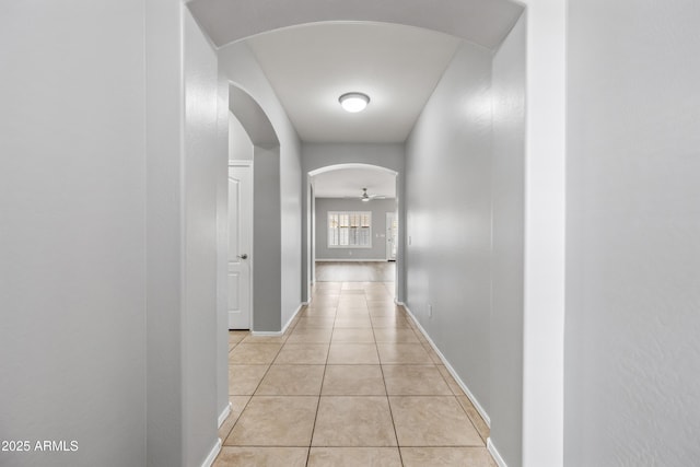 16763 W Magnolia St, Goodyear, AZ 85338 - hall featuring arched walkways, light tile patterned floors, and baseboards