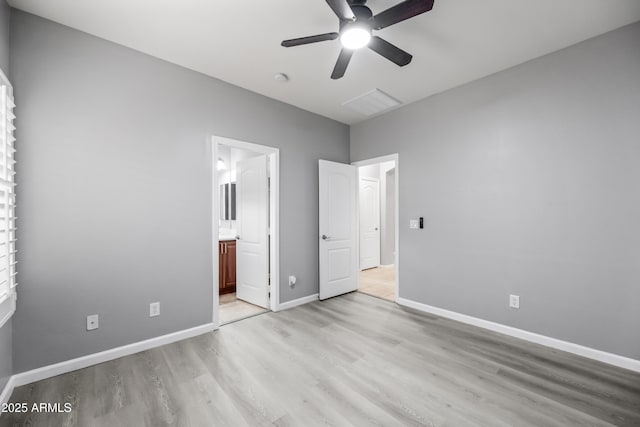 16763 W Magnolia St, Goodyear, AZ 85338 - unfurnished bedroom featuring light wood-type flooring, baseboards, ensuite bath, and a ceiling fan