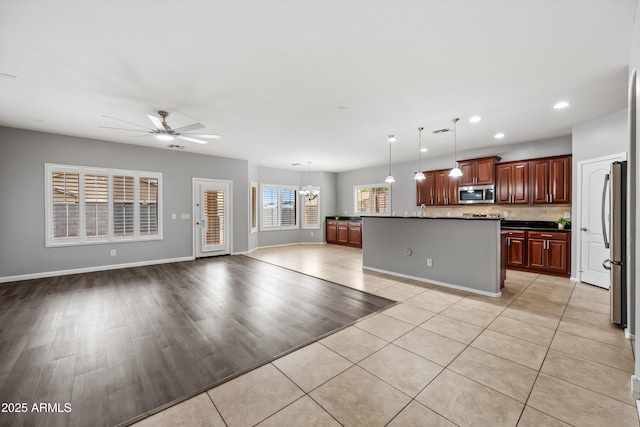 16763 W Magnolia St, Goodyear, AZ 85338 - kitchen featuring stainless steel appliances, dark countertops, ceiling fan, recessed lighting, and open floor plan