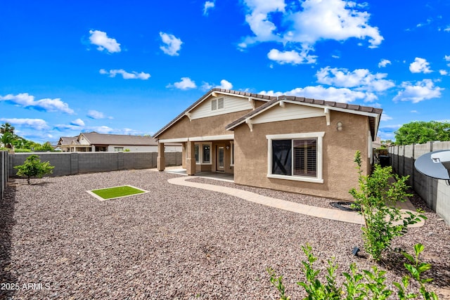 16763 W Magnolia St, Goodyear, AZ 85338 - back of house featuring stucco siding, a fenced backyard, a tile roof, and a patio area
