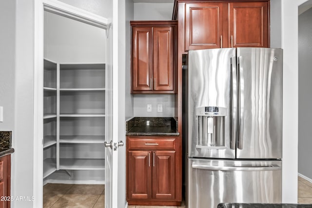 16763 W Magnolia St, Goodyear, AZ 85338 - kitchen featuring stainless steel fridge, light tile patterned flooring, and dark stone countertops