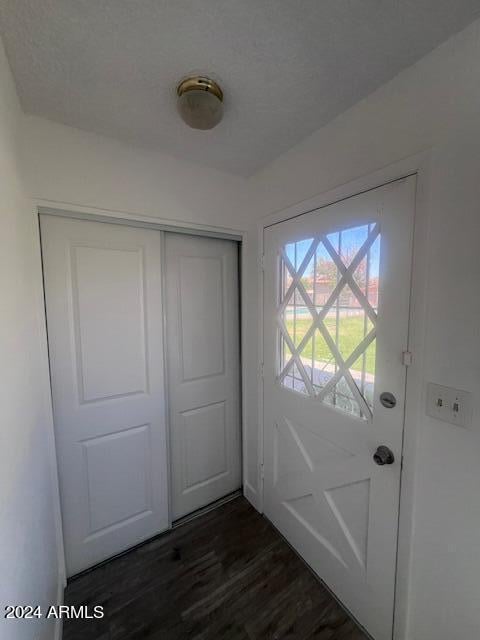 entryway featuring a textured ceiling and dark hardwood / wood-style floors