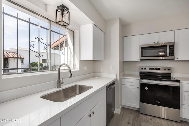 kitchen featuring sink, white cabinets, and appliances with stainless steel finishes