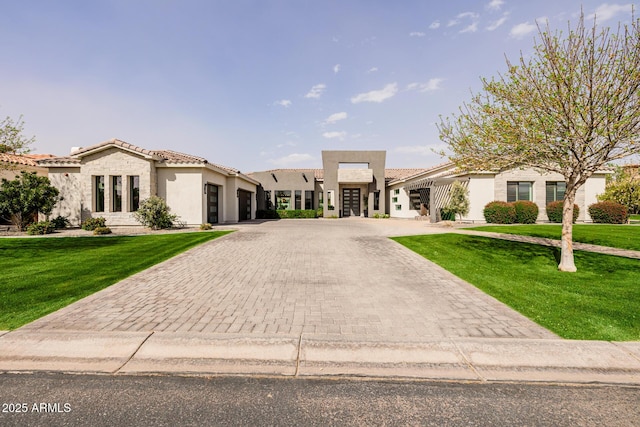 view of front facade with stone siding, a tiled roof, an attached garage, decorative driveway, and a front lawn