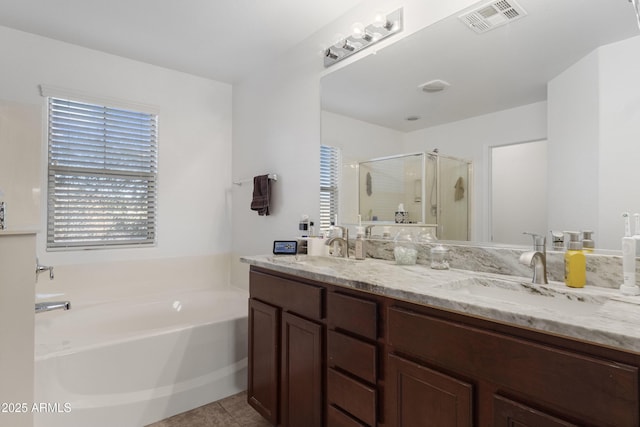 bathroom with tile patterned floors, vanity, and shower with separate bathtub