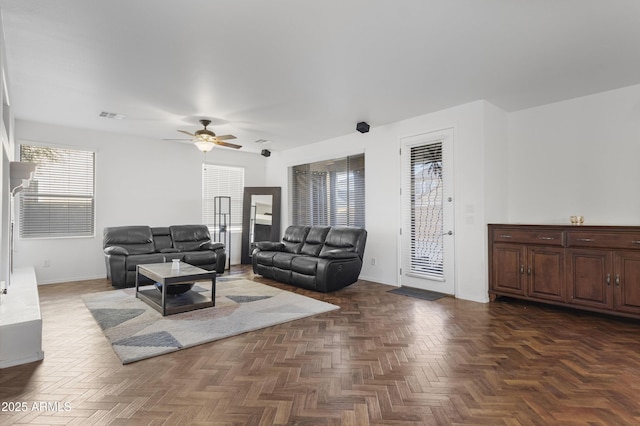 living room with ceiling fan and dark parquet floors