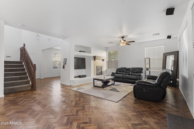 living room with ceiling fan and dark parquet floors