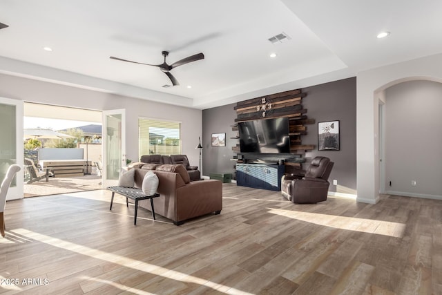 living area featuring arched walkways, recessed lighting, a ceiling fan, wood finished floors, and baseboards