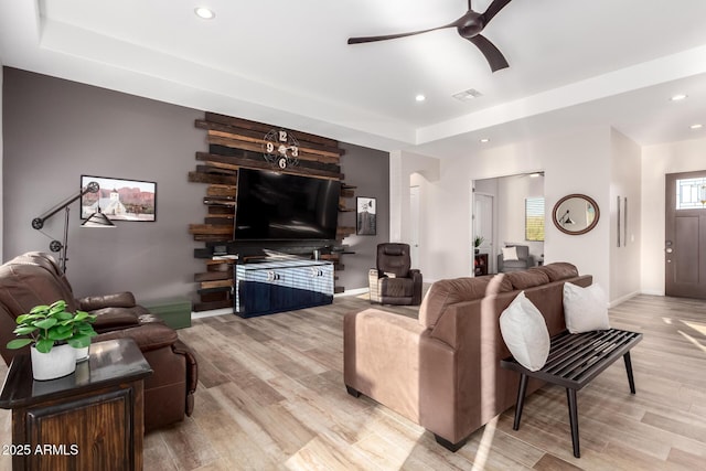 living room featuring light wood-type flooring, visible vents, a ceiling fan, and recessed lighting