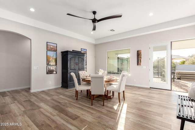 dining area featuring arched walkways, ceiling fan, light wood-style flooring, recessed lighting, and baseboards