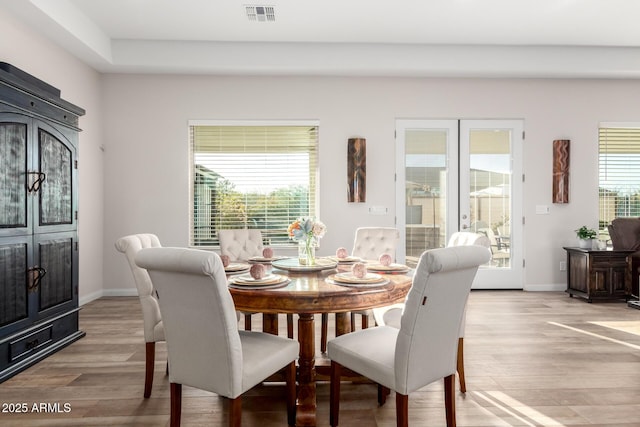 dining room with french doors, visible vents, baseboards, and light wood finished floors