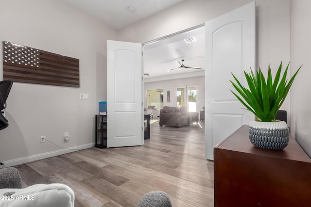 interior space with baseboards, visible vents, ceiling fan, and wood finished floors