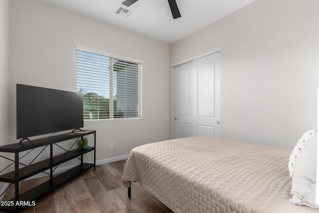 bedroom featuring wood finished floors, a ceiling fan, visible vents, baseboards, and a closet