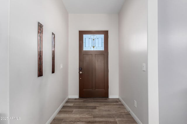 doorway with baseboards and wood finished floors