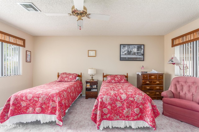 bedroom with carpet floors, visible vents, ceiling fan, and multiple windows