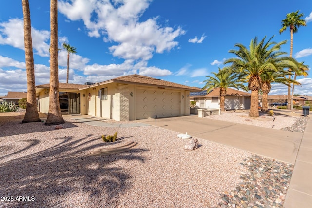 view of front of home with driveway, brick siding, and an attached garage