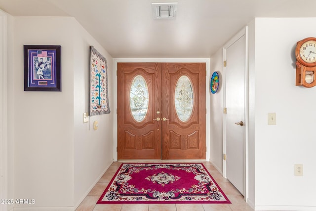 entrance foyer featuring light tile patterned floors, visible vents, and baseboards